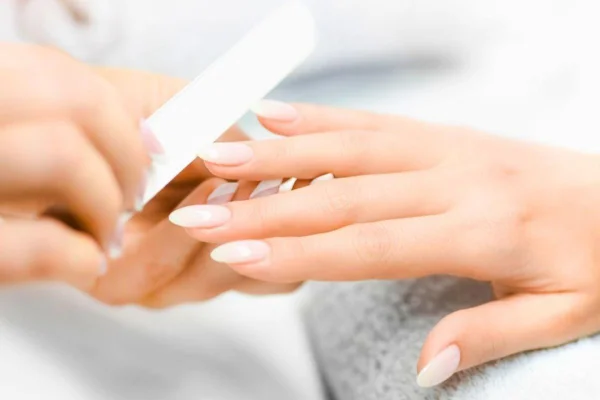 Unhas de mão feminina sendo feitas