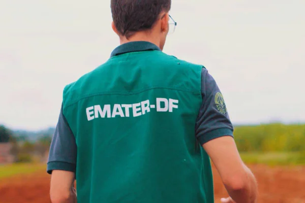 Foto colorida de homem com colete com logo da emater df