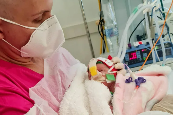 Mulher em tratamento contra o câncer segura sua bebê - Metrópoles