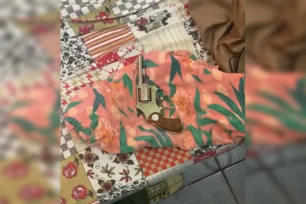 Arma de fogo em cima de lençol de cama