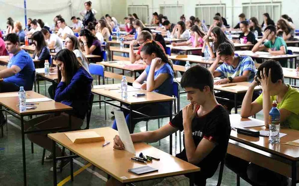 Na foto, alunos fazem prova em uma sala de aula
