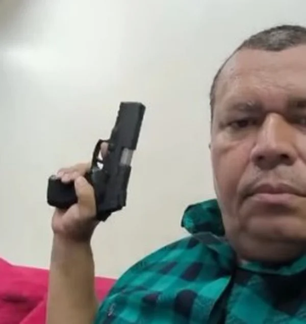 Imagem colorida. Homem com arma na mão