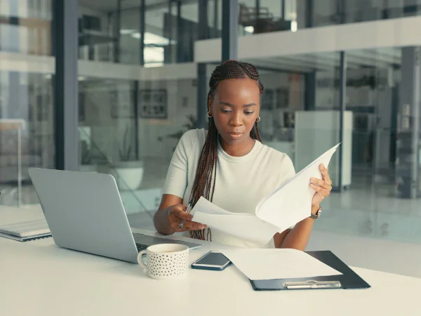 Foto colorida de jovem negra se candidatando à vaga de emprego através do computador. Imagem ilustrativa - Metrópoles