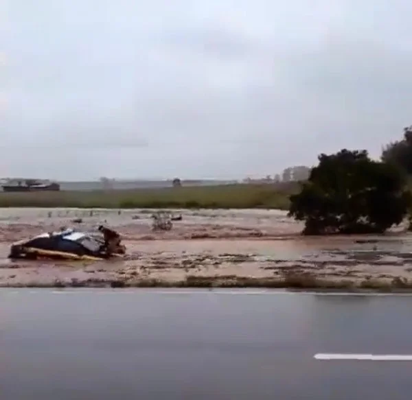 Imagem colorida do Policial Rodoviário Federal (PRF) fica ilhado em capô do carro em enchente - Metrópoles