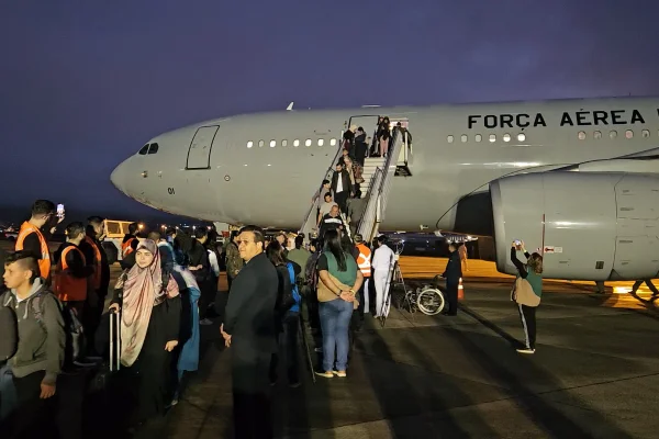 Imagem colorida de pessoas desembarcando de avião da FAB