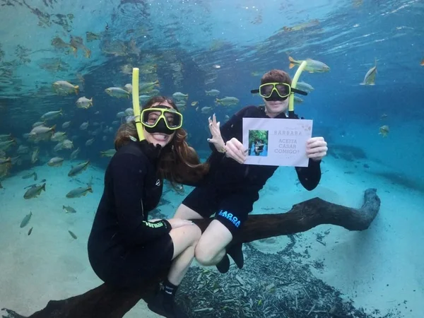 foto colorida de casal embaixo d'água