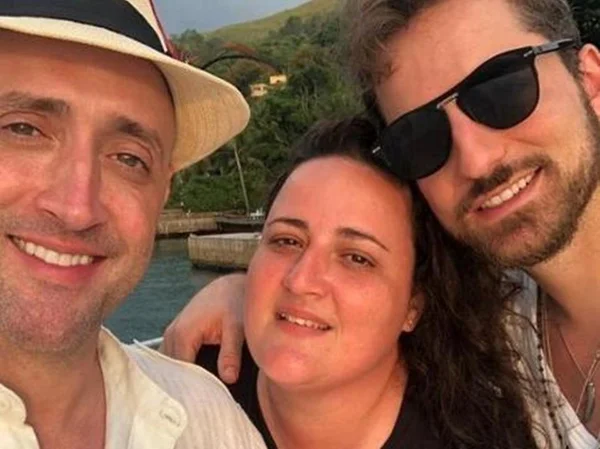 Paulo Gustavo, Juliana Amaral e Thales Bretas abraçados durante viagem e passeio de barco no mar