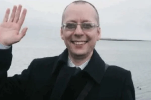 Boris Bondarev, conselheiro russo na ONU que renunciou por "vergonha de seu país". Ele é branco, careca, usa óculos e sorri, acenando - Metrópoles