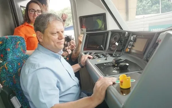 Foto colorida do governador Tarcísio de Freitas sentado de camise dentro de cabine de trem - Metrópoles