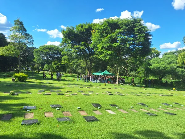 Imagem colorida mostra um cemitério com várias pessoas em torno de um caixão sendo sepultado; o enterro é de duas vítimas de um acidente de helicóptero no interior de São Paulo - Metrópoles