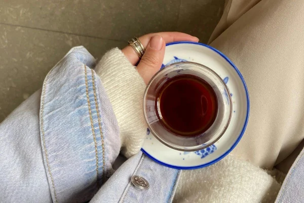 foto colorida de pessoa segurando xicara com infusão