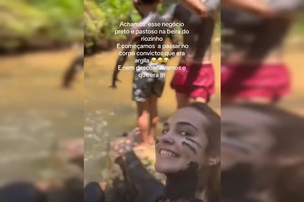 Imagem colorida de crianças e adolescentes sujos de lama no riacho - Metrópoles