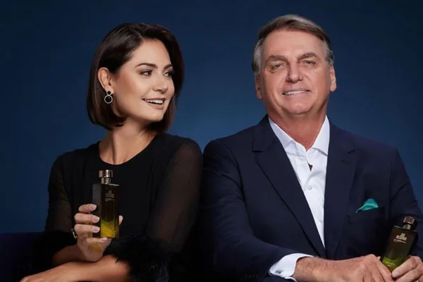 Foto colorida de Michelle Bolsonaro e Jair Bolsonaro com linha de perfume - Metrópoles