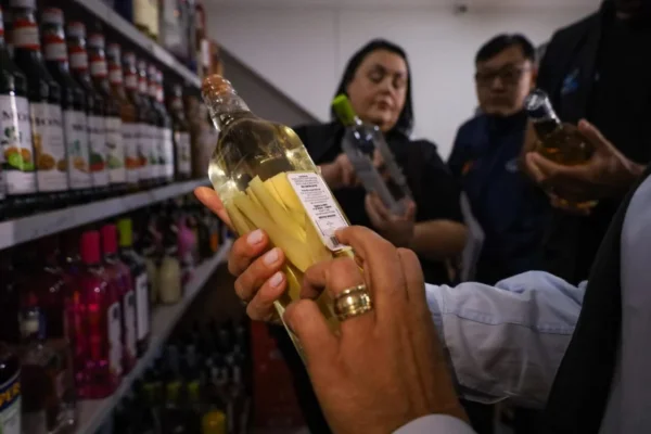 Foto colorida mostra agentes do Procon apreendendo bebidas suspeitas de falsificação no Paraná