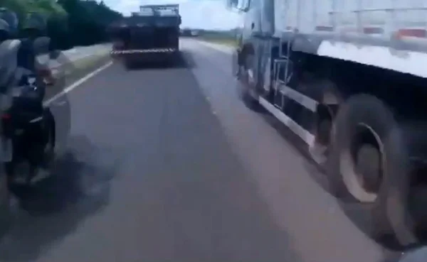 Imagem colorida mostra motociclista momentos antes de bater em caminhão e voar em rodovia no interior de São Paulo - Metrópoles