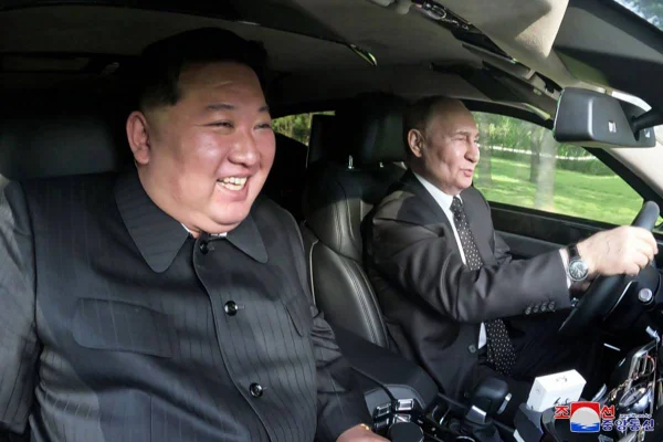 Imagem colorida mostra Vladimir Putin e Kim Jong-un durante passeio em um veículo - Metrópoles