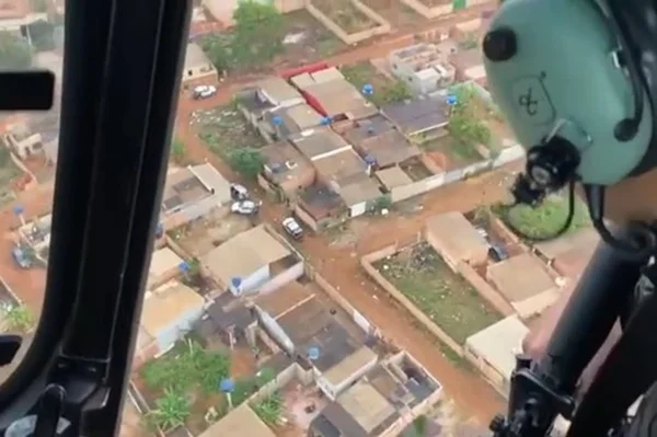 Homem em helicóptero olhando para cidade embaixo