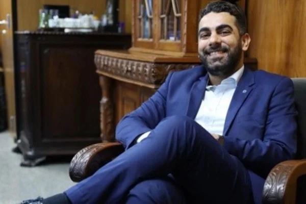 Homem de terno e pernas cruzadas