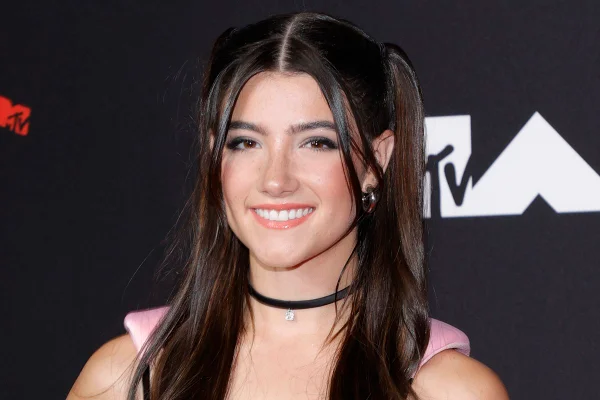 Adolescente maquiada com penteado no cabelo e colar preto