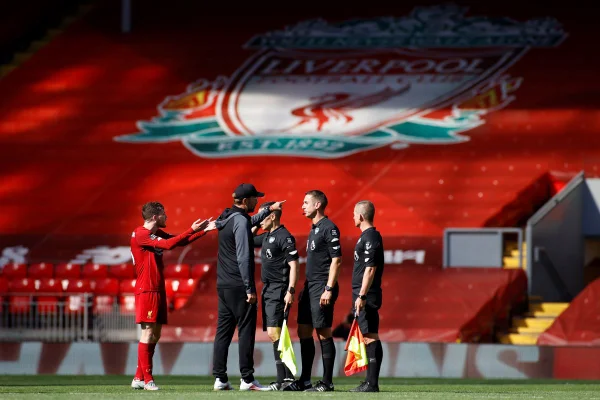 Foto colorida do técnico Jurgen Klopp, então no Liverpool, conversando com o árbitro David Coote e seus assistências após partida em 2020 - Metrópoles