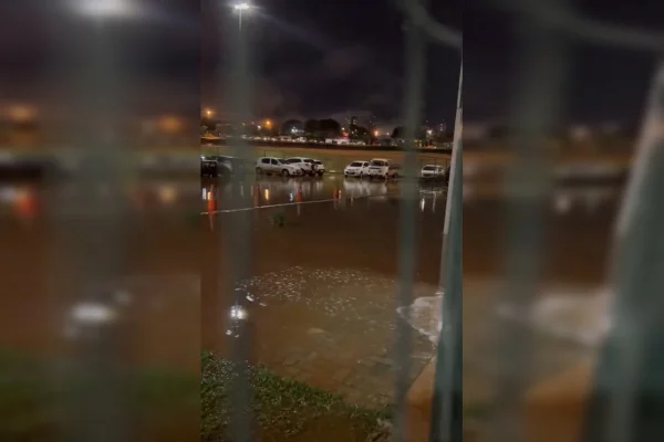 imagem mostra estacionamento ao ar livre alagado