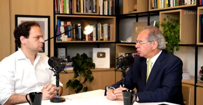 Paulo Guedes e homem em uma mesa / reprodução YT