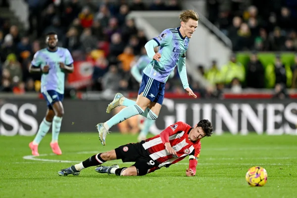 Foto colorida de Norgaard e Odegaard em disputada de bola durante Brentford e Arsenal - Metrópoles