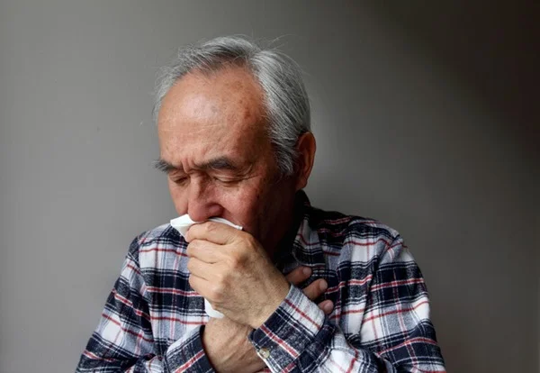 Homem tossindo com a mão na boca - Metrópoles