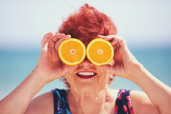 Imagem mostra idosa na praia, com duas metades de uma laranja no lugar dos olhos - Metrópoles