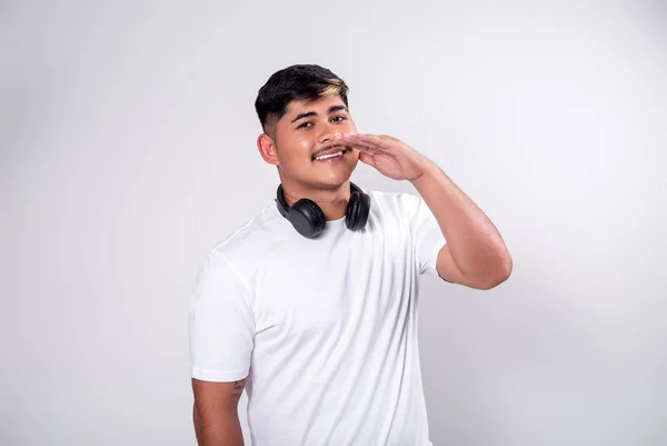 homem de camisa branca e fone de ouvido preto - Metrópoles