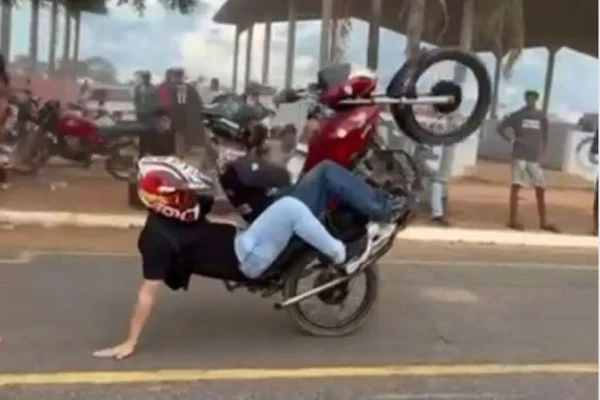 Imagem colorida, prefeito empinando na garupa da moto- Metrópoles