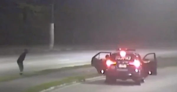 Imagem colorida mostra carro de polícia abordando homem suspeito de furtar cemitério em avenida de Santos - Metrópoles