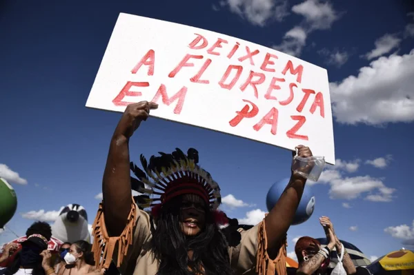 indígena em protesto na esplanada segura cartaz