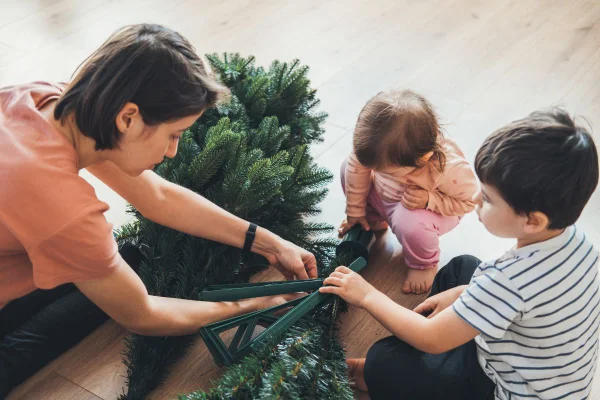 Foto colorida família desmontando árvore de Natal