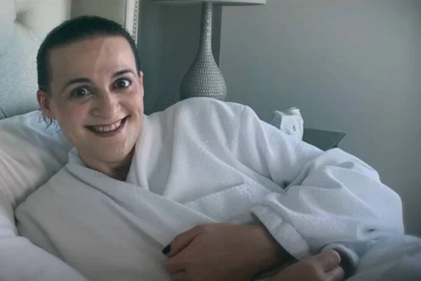 Imagem colorida de mulher usando roupão, com o cabelo curto e sorrindo - Metrópoles