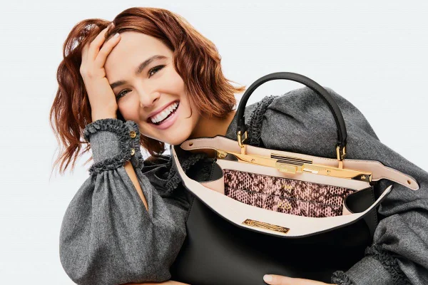 Atriz Zoey Deutch, em campanha para Fendi, sorrindo com uma Peekaboo preta