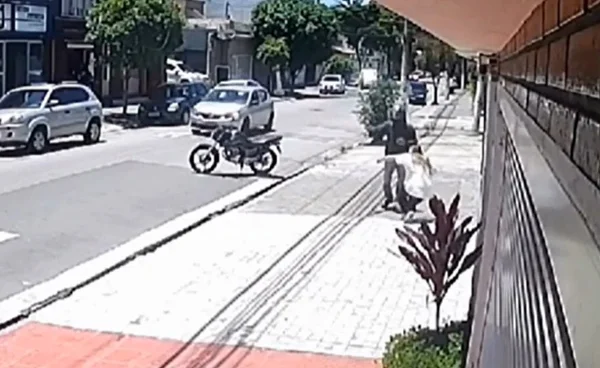 Imagem colorida mostra mulher desmaiando logo após ser assaltada por um motociclista no bairro do Sacomã - Metrópoles