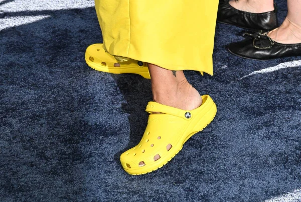 foto com cor. crocs amarela nos pés de mulher que usa calça amarela - metrópoles