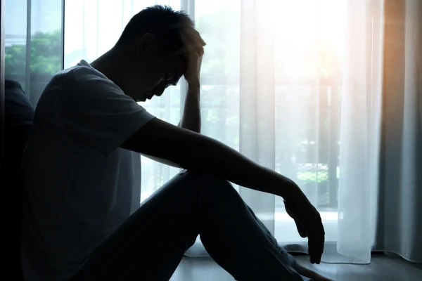 Foto do homem sentado no canto da sala tem problemas emocionais e mentais Ele tem depressão - Metrópoles