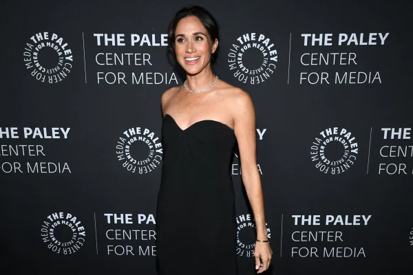 Foto colorida de mulher com vestido preto posando para fotos - Metrópoles