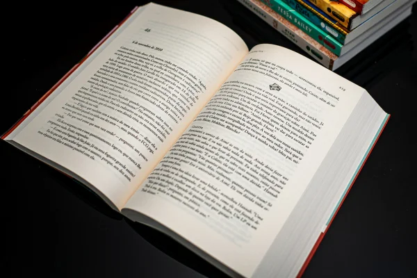 Imagem colorida mostra um livro aberto sob a mesa - Metrópoles