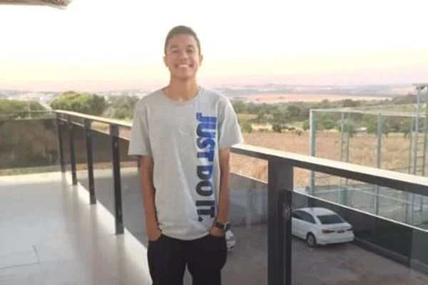 Jovem em pé com mãos nos bolsos