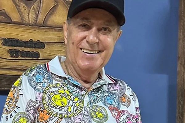 Milionário, da dupla com José Rico posa, sorridente, de camisa colorida e boné preto - Metrópoles