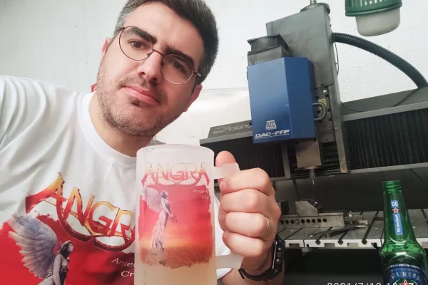 Homem branco com camseta branco de banda de rock e caneca com a mesma estampa da camiseta - Metrópoles