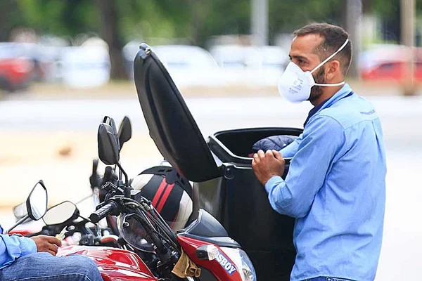 Motoboy com máscara no SCS