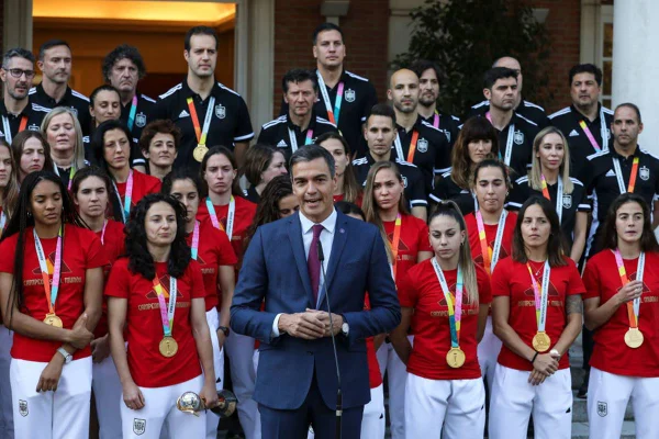Imagem colorida do primeiro-ministro da Espanha e jogadoras - Metrópoles
