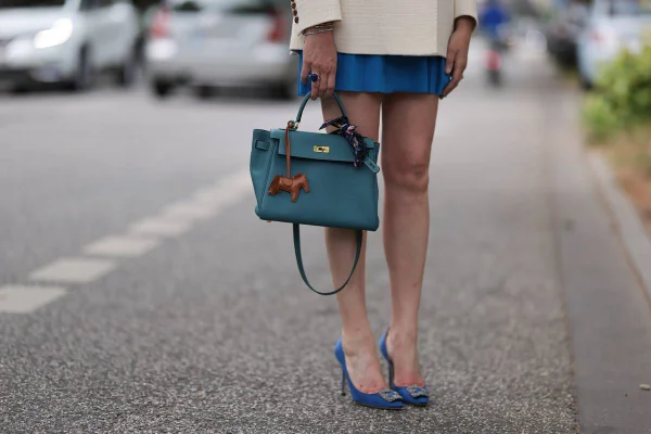 Look de street style com bolsa de mão e sapatos de salto alto - Metrópoles