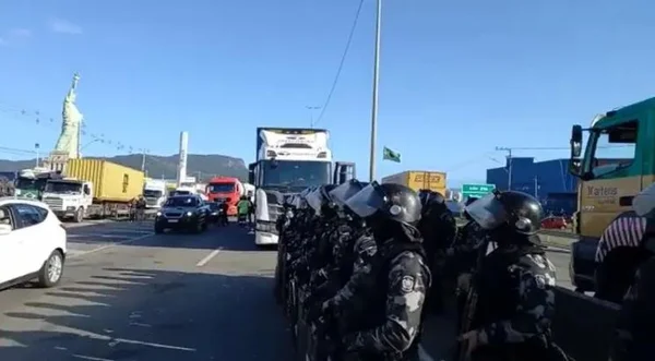 Tropa de Choque de SC na estrada com caminhão ao fundo