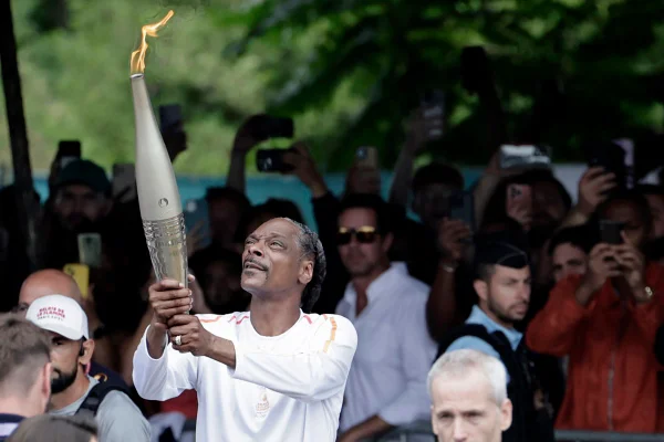 Snopp Dogg levantando a tocha nas Olímpiadas de Paris 2024