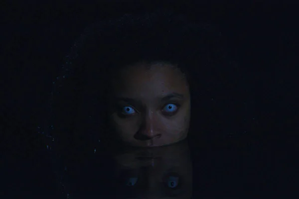 Foto de uma mulher negra com olhos azulados dentro do mar - Metrópoles